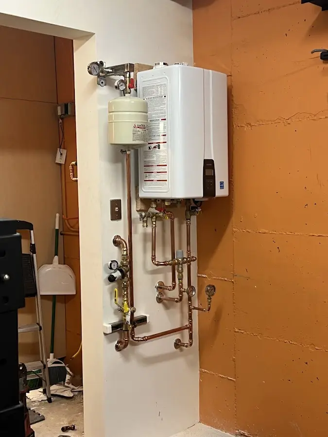 Plumbing technician inspecting water heater connections in Fairview